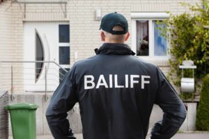 Become debt free, image Bailiff looks at a property
